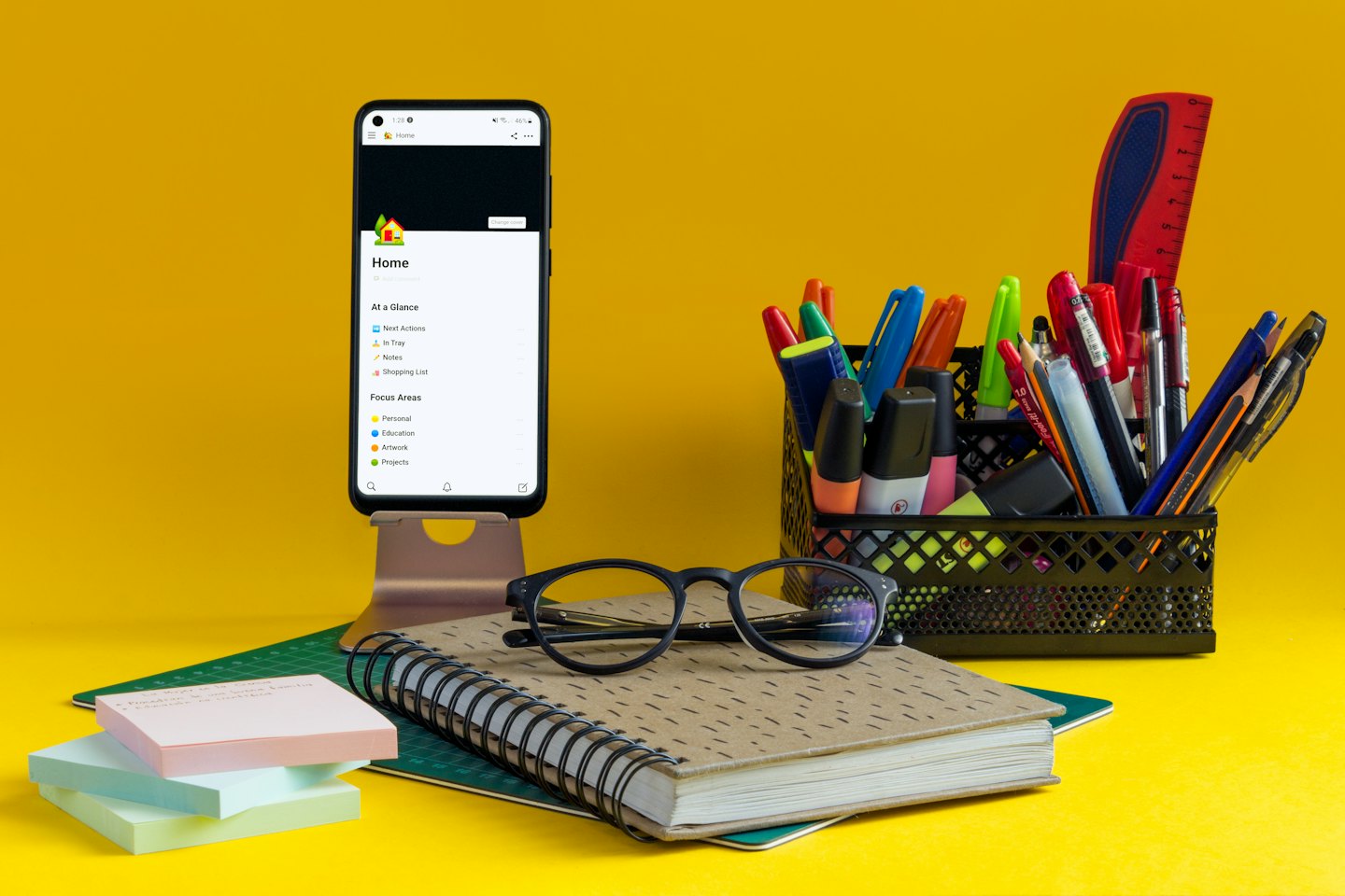 Productivity tools and stationery arranged on a yellow surface.